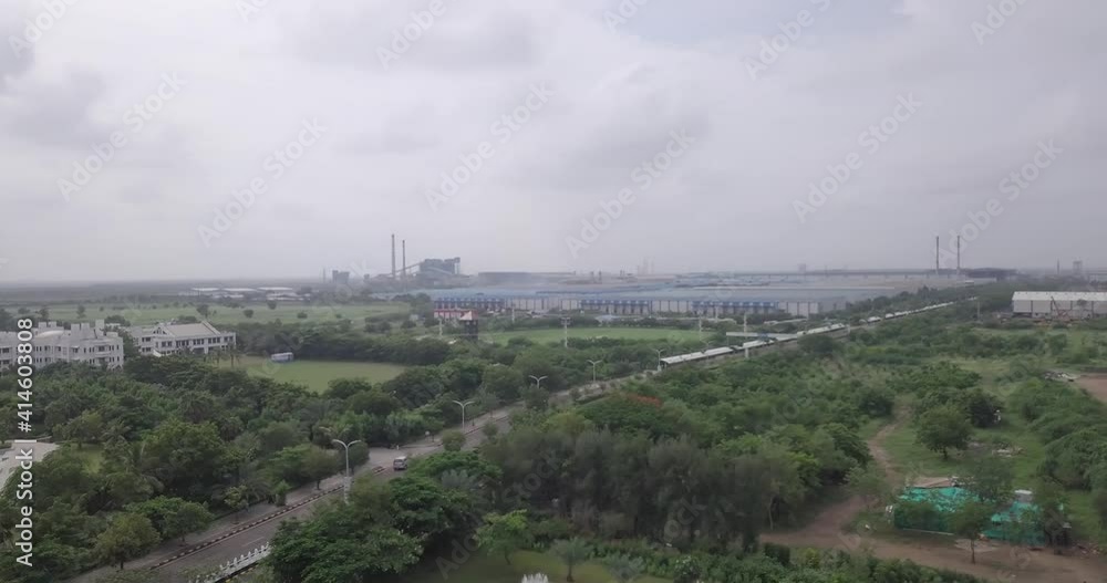 Industrial City Landscape With Cars Traveling On Pavement Road Between Dense Trees During Daytime. - Aerial Drone Shot Industrial City Landscape With Cars Traveling On Pavement Road Between Dense Trees During Daytime. - Aerial Drone Shot