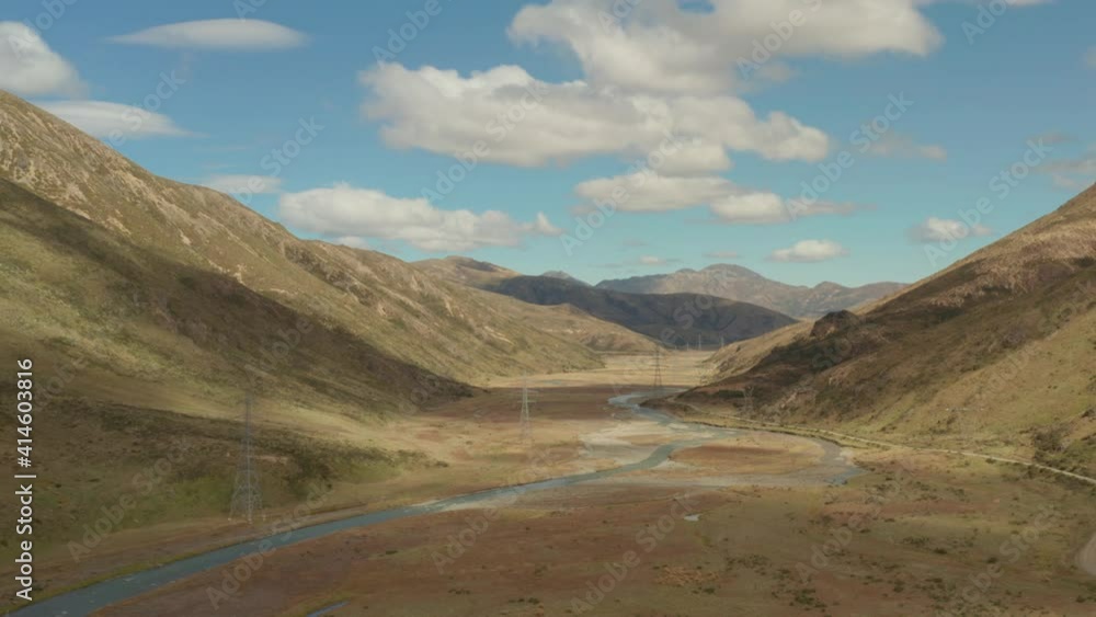 Aerial view of a valley with a narrow winding river and some high voltage towers in New Zealand. Aerial view of a valley with a narrow winding river and some high voltage towers in New Zealand.