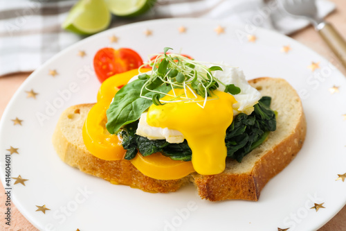 Vászonkép Tasty sandwich with florentine egg and fresh vegetables on plate, closeup