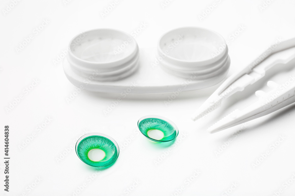 Tweezers, contact lenses and container on white background Tweezers, contact lenses and container on white background