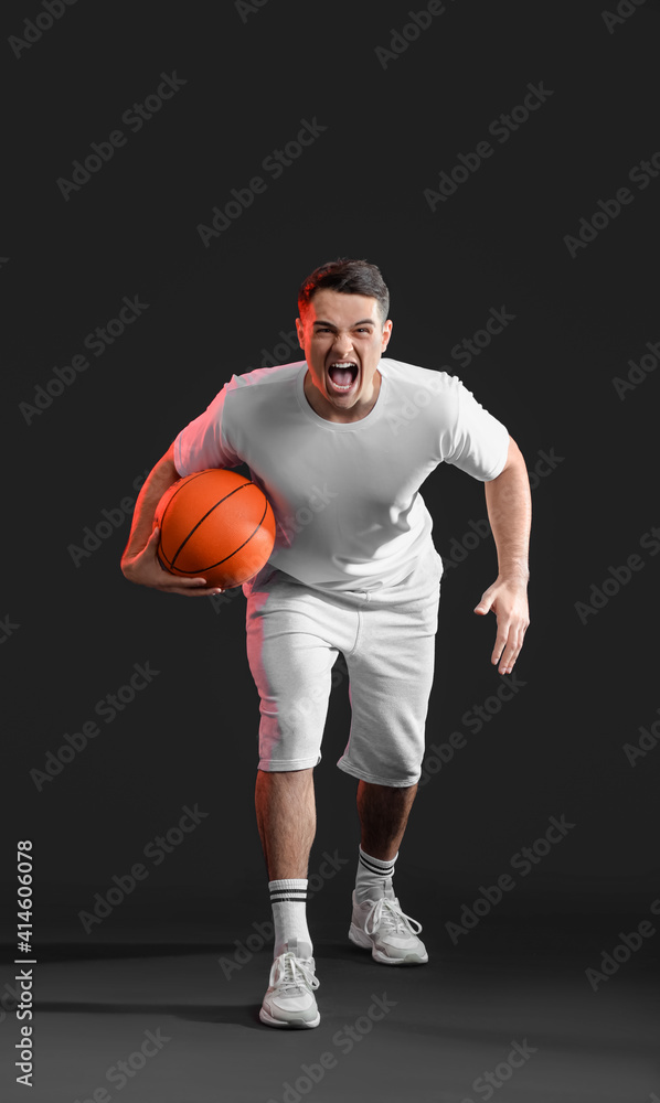 Aggressive basketball player on dark background Aggressive basketball player on dark background