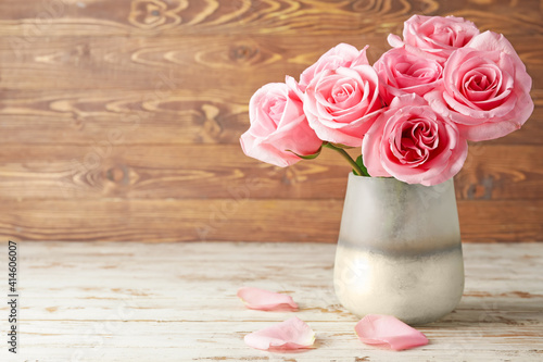Beautiful pink roses in vase on wooden background © Pixel-Shot