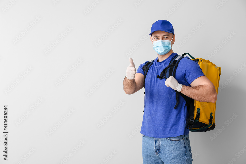 Courier of food delivery service showing thumb-up on light  background