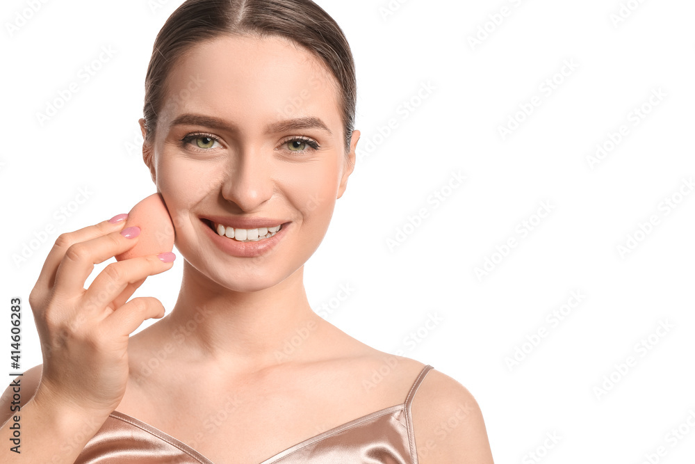 Beautiful young woman with makeup sponge on white background Beautiful young woman with makeup sponge on white background