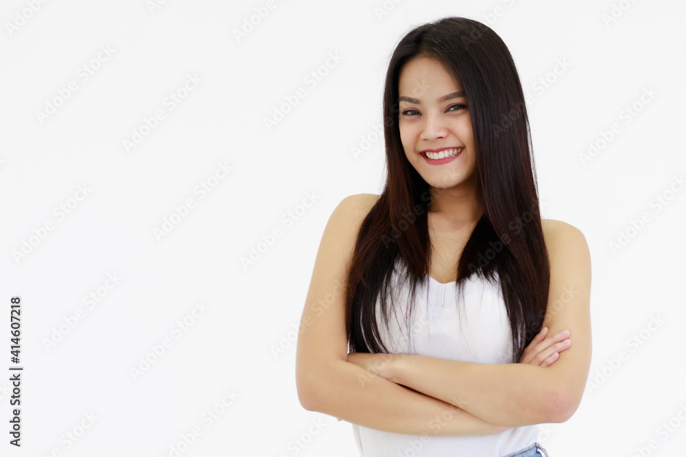 Portrait of One Asian adult woman with long black hair standing, smiling and looking at a camera with hands in blue jean. Woman wear a white camisole and jeans shoot with white background in a Studio Portrait of One Asian adult woman with long black hair standing, smiling and looking at a camera with hands in blue jean. Woman wear a white camisole and jeans shoot with white background in a Studio