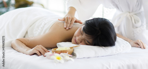 Adult asian woman with long black hair laying on spa bed with a white towel on her. Sleep and feel relax when massage spa oil to back and press of back body from massage spa service