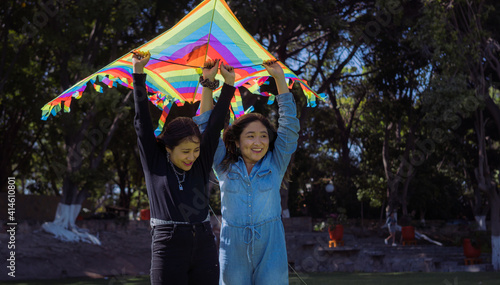 Teenage sisters flying kites in a park 