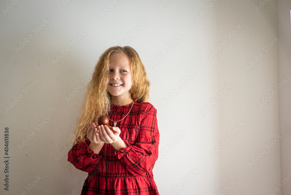 Fototapeta premium girl in a red dress with easter eggs, selective focus