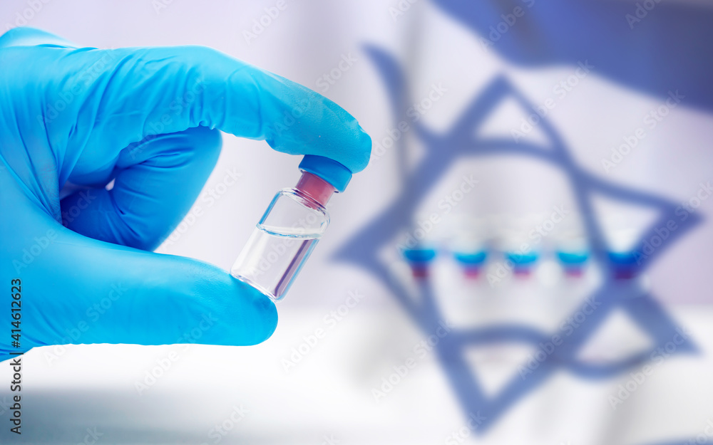 Close up on vaccine and medical syringe, Israel flag in the background