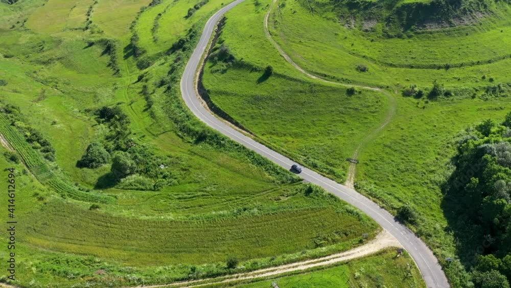 Flying over a car passing on a countryside road, aerial view Flying over a car passing on a countryside road, aerial view