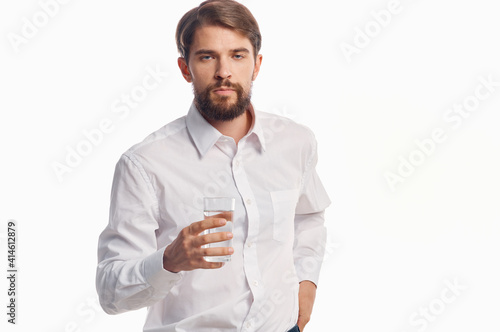 handsome man with glass of water healthy lifestyle white shirt light background
