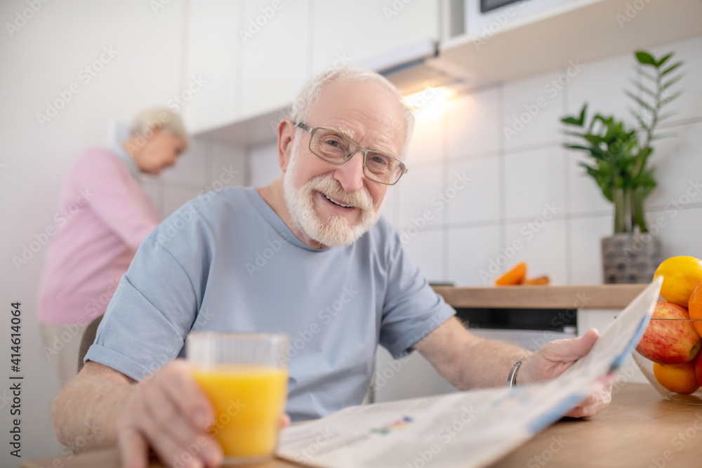 Senior grey-haired man sitting at the table in the kitchen Senior grey-haired man sitting at the table in the kitchen