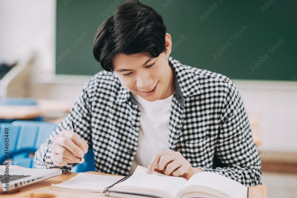 Young cheerful asian student studying in classroom Young cheerful asian student studying in classroom