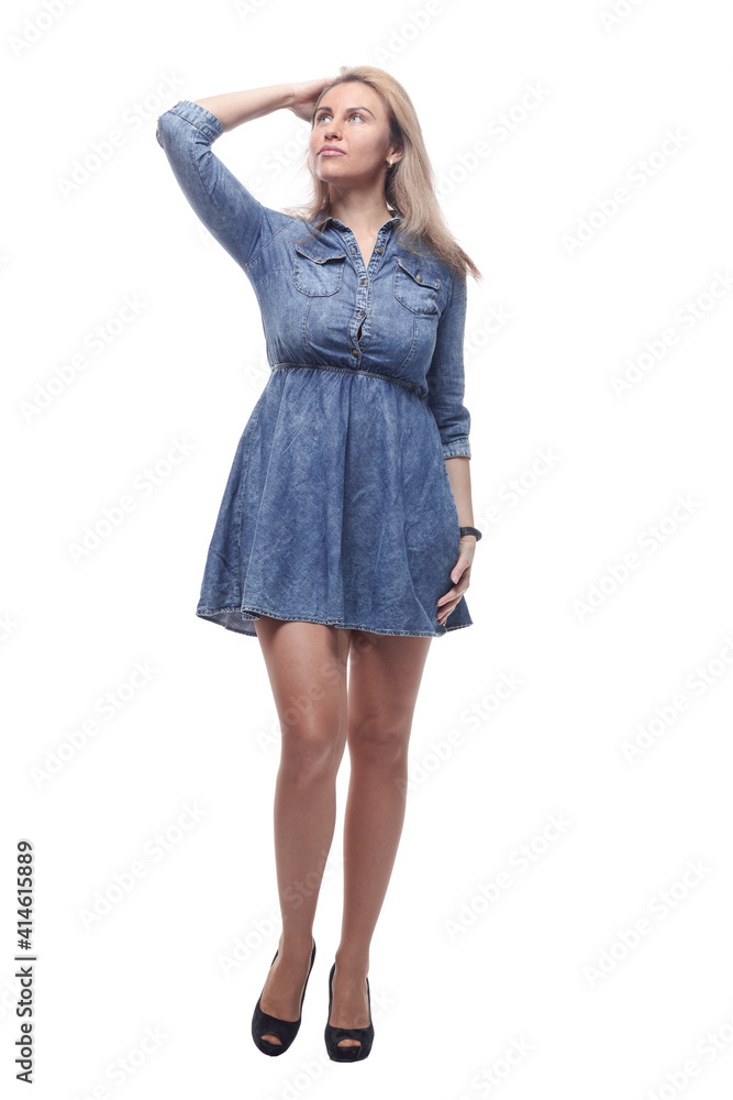 thoughtful young woman in a denim dress looking at a white screen. thoughtful young woman in a denim dress looking at a white screen.