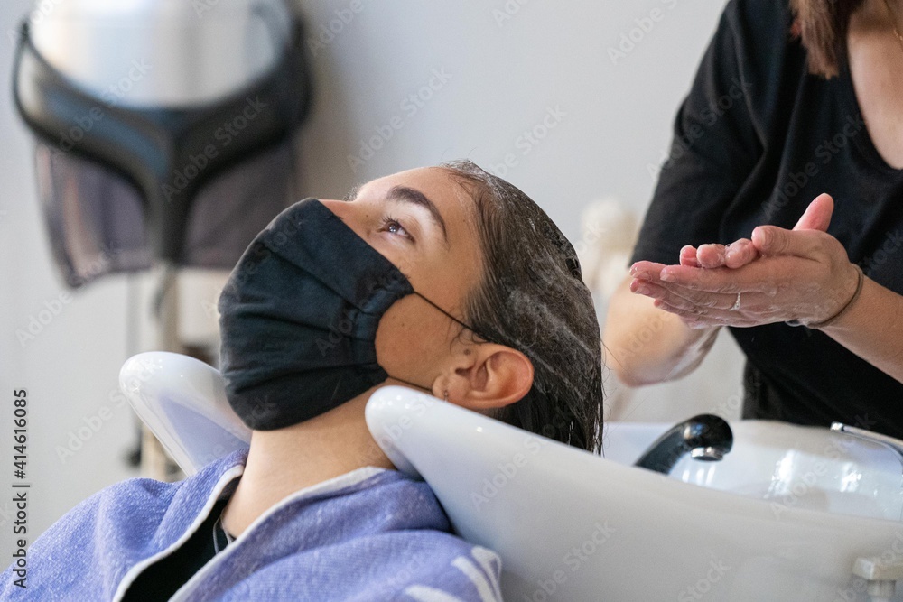 Young hairdresser washing her client's hair Young hairdresser washing her client's hair