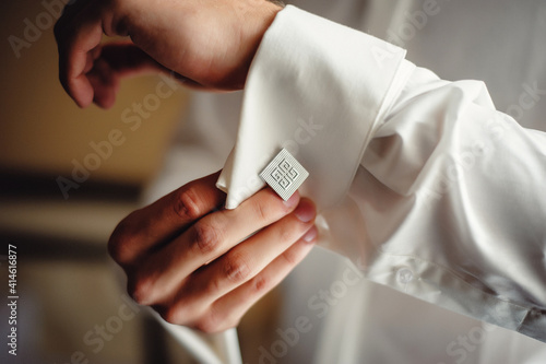 Foto A successful man wears silver cufflinks on the cuff of a white shirt