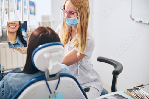 Attentive dentist looking at the result of her work