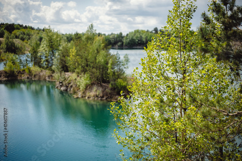 Fototapeta Naklejka Na Ścianę i Meble -  Lake on the background of rocks and fir trees. Canyon. The nature of spring, summer. Place for text and design. Landscape of an old flooded industrial granite quarry filled with water.