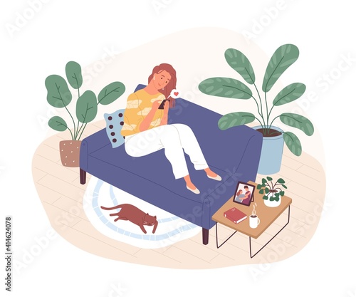 Young woman sitting on couch at home and chatting online in dating app. Virtu...