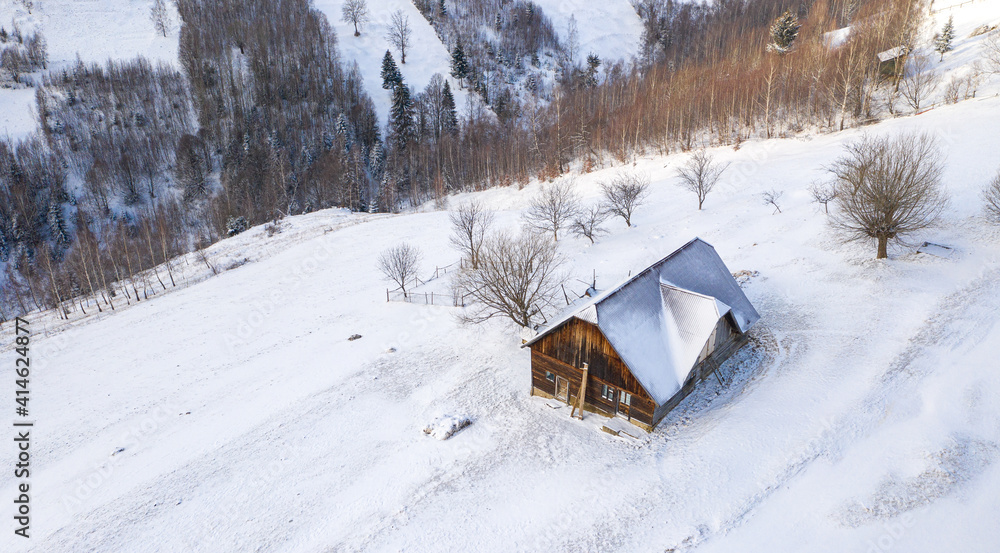 Aerial scenic rural view over Pestera village at the bottom of Piatra-Craiului Mountains during a freezing winter in Romania with authentic houses Aerial scenic rural view over Pestera village at the bottom of Piatra-Craiului Mountains during a freezing winter in Romania with authentic houses