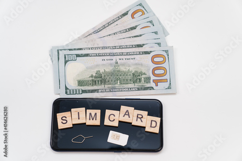 Wallpaper Mural inscription on cubes and sim card and the on smartphone, and dollar banknotes. concept of paying for mobile and the Internet. daily communications costs Torontodigital.ca