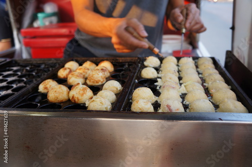 Employees are making Japanese food takoyaki. 