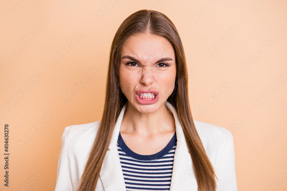 Photo of angry young lady frowning look camera wear white jacket isolated pastel beige color background Photo of angry young lady frowning look camera wear white jacket isolated pastel beige color background