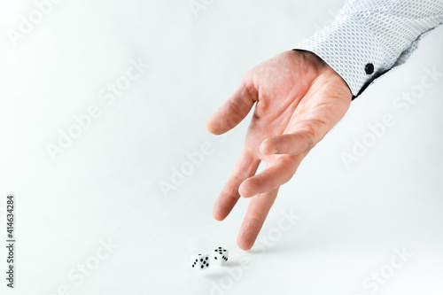 hand throws dice on white background with copy space.  photo