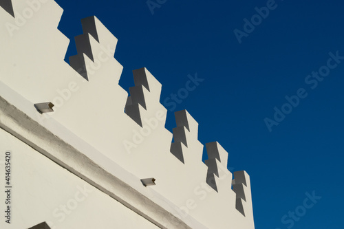 white arabic arches mosque architecture with blue sky in the background