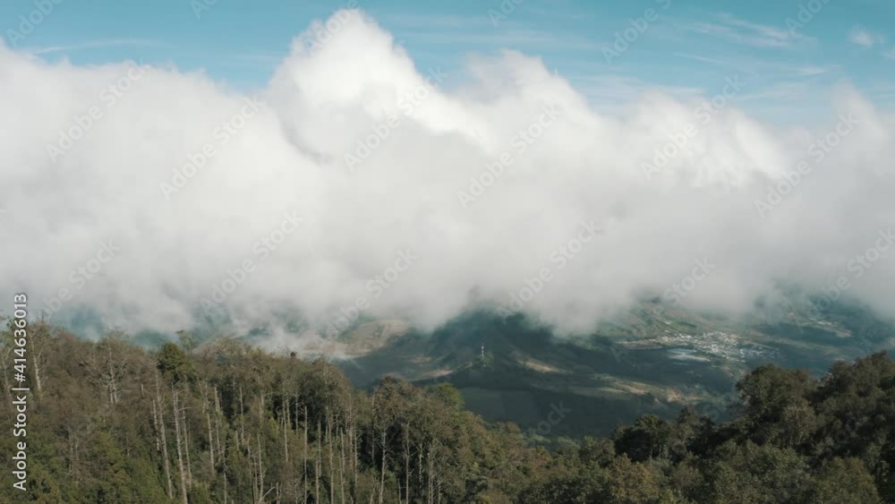 Drone aerial view, flying high over the forest of Acatenango volcano, Guatemala, clouds moving during windy weather Drone aerial view, flying high over the forest of Acatenango volcano, Guatemala, clouds moving during windy weather