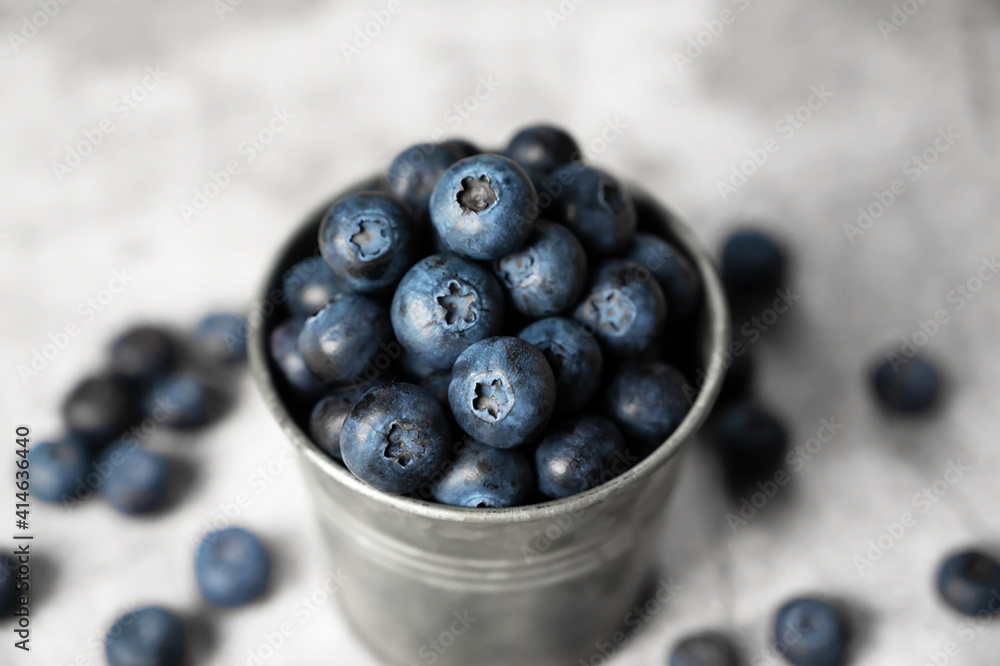 Fresh blueberries in a small metal bucket surrounded with some berries against concrete background. Top view. Rustic. Fresh blueberries in a small metal bucket surrounded with some berries against concrete background. Top view. Rustic.
