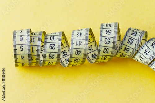 centimeters measure tape on yellow background