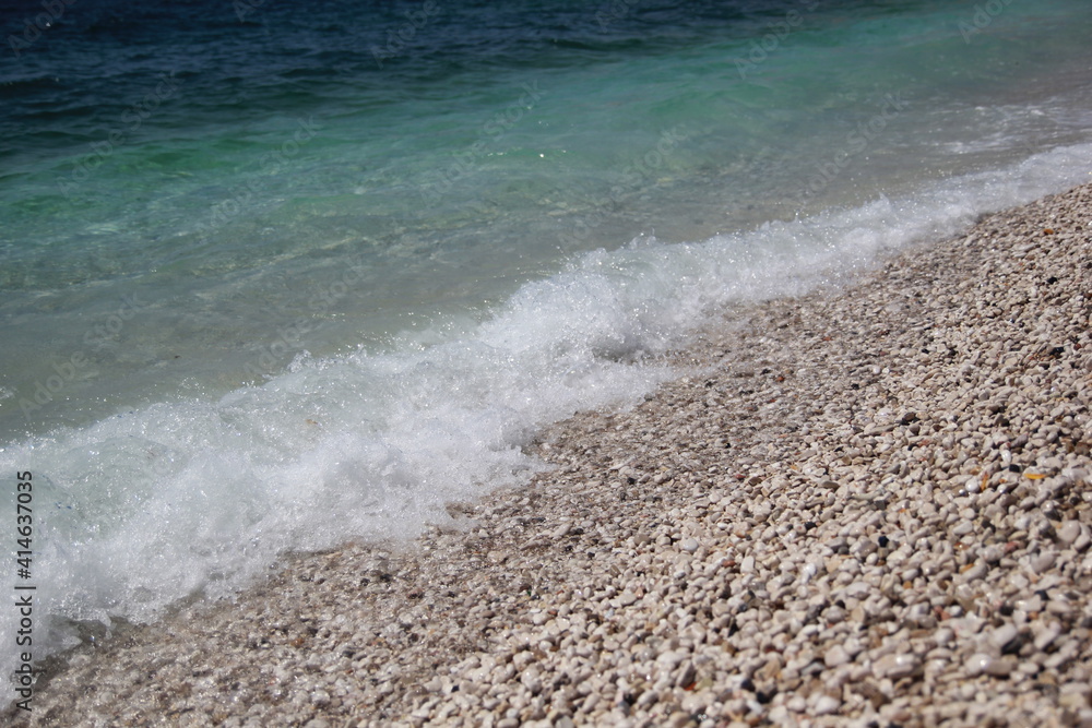White pebbles and beautiful sea with a rolling wave, beautiful texture of the beach White pebbles and beautiful sea with a rolling wave, beautiful texture of the beach