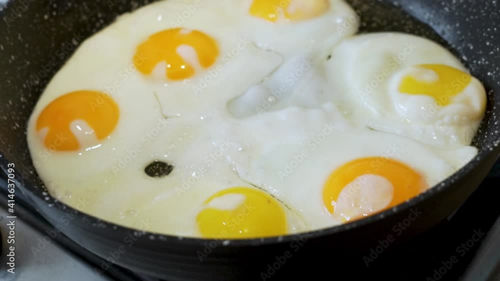 Cooking Food. Cooking Scrambled Eggs from Six Eggs. Frying Eggs on the Stove in a Frying Pan, Close-up. Boiling, Frying Eggs. The Concept of Protein Healthy Food and Diet. Cooking Food. Cooking Scrambled Eggs from Six Eggs. Frying Eggs on the Stove in a Frying Pan, Close-up. Boiling, Frying Eggs. The Concept of Protein Healthy Food and Diet.