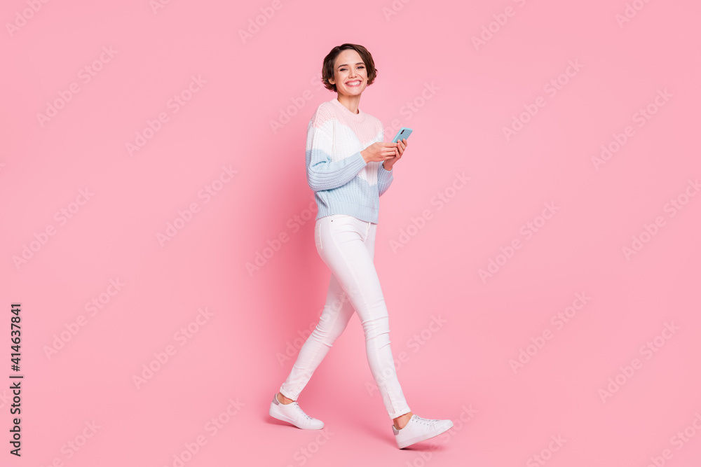 Full body photo of charming positive person walking look camera beaming smile isolated on pink color background Full body photo of charming positive person walking look camera beaming smile isolated on pink color background