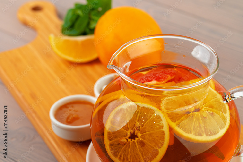 Glass teapot with black tea and pieces of citrus Glass teapot with black tea and pieces of citrus