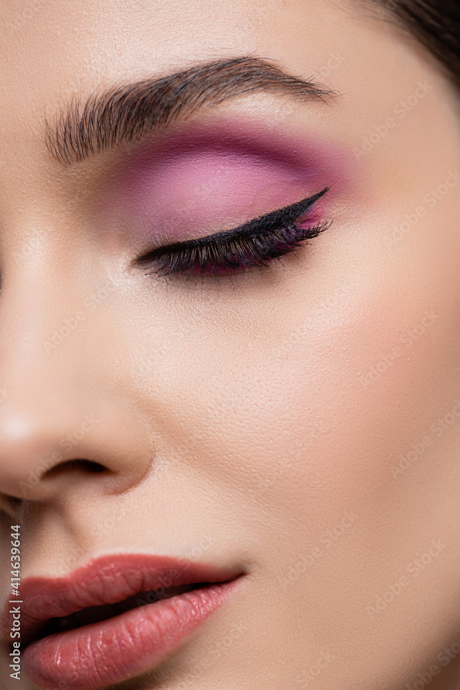 close up of woman with pink eye shadows isolated on grey
