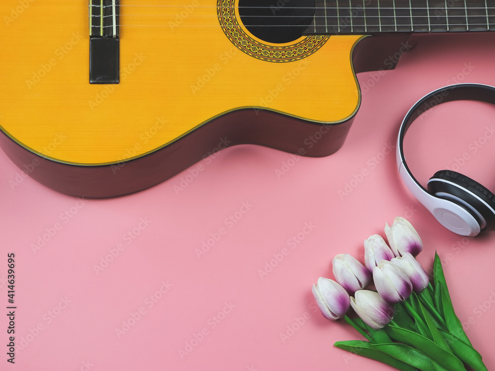 flat lay of acoustic guitar, white headphones on pink background with tulip  flowers decoration. spring, love song and leisure. Stock Photo | Adobe Stock