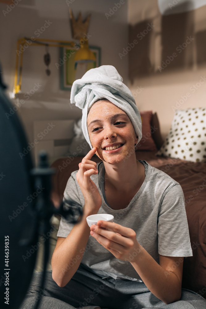 teenage girl applying cosmetic face mask in her room. teenage girl applying cosmetic face mask in her room.