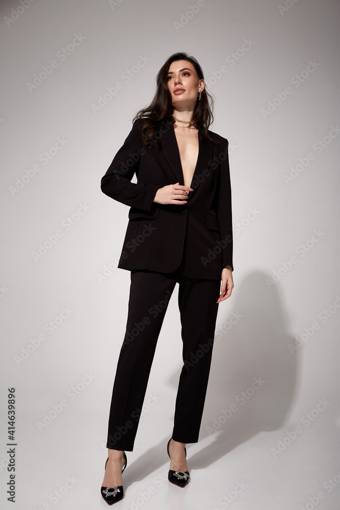 Fashion beauty model dark hair style beautiful sexy pretty woman perfect skinny body shape cosmetic makeup face wear clothes black trend suit silk pants jacket accessory shoes studio background. Fashion beauty model dark hair style beautiful sexy pretty woman perfect skinny body shape cosmetic makeup face wear clothes black trend suit silk pants jacket accessory shoes studio background.