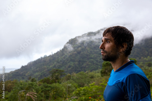 Trekker on the mountain landscape. A lonely man on the background of the mountains. Trekking in the mountains. A male face with space for text.