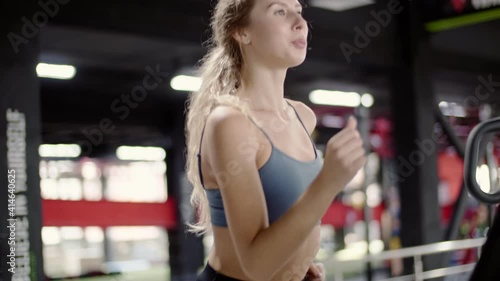 Fitness woman cardio workout jogging on treadmill in gym photo