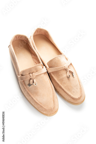 Pair of beige modern unisex loafers on white background