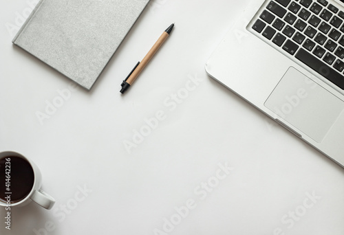 Freelancer desk with macbook on white background near notepad and pen