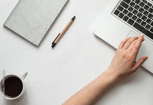Freelancer desk with macbook on white background near notepad and pen