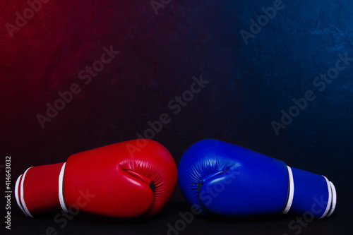 Boxing gloves Red and Blue hitting together poster design. © stasnds