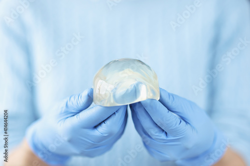 Silicone breast implant in hands of doctor
