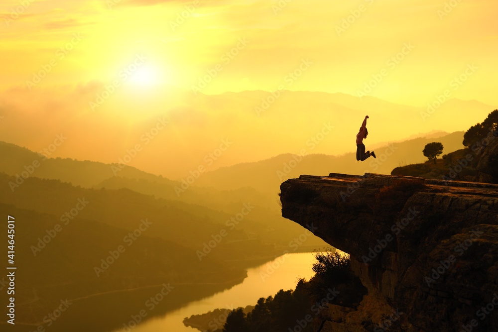 Fototapeta premium Happy woman silhouette jumping in the mountain on vacation