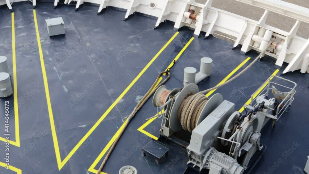 Mooring rope being winched back on deck using an electric winch before departure Mooring rope being winched back on deck using an electric winch before departure