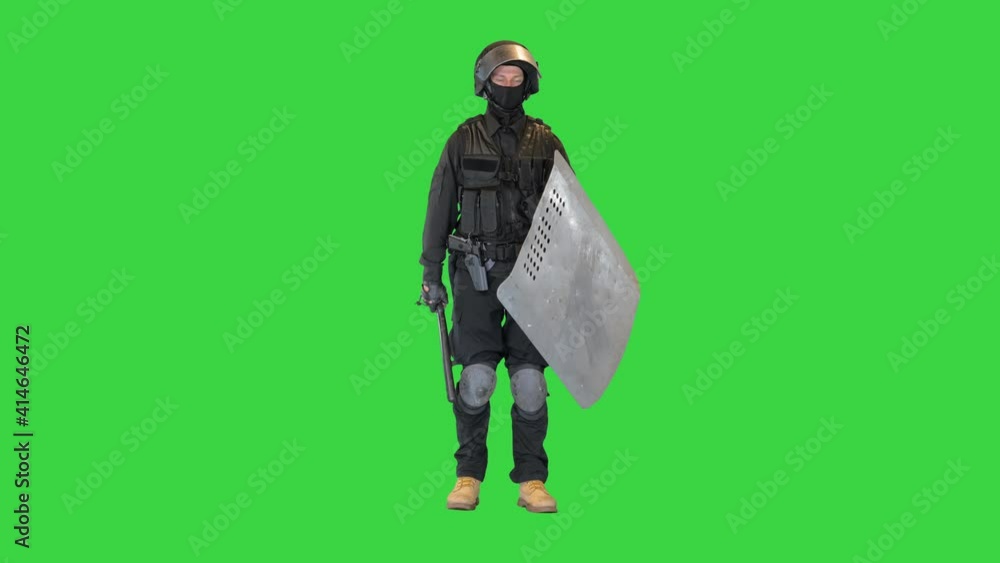 Special unit riot policeman with a shield and baton standing waiting on a Green Screen, Chroma Key. Special unit riot policeman with a shield and baton standing waiting on a Green Screen, Chroma Key.